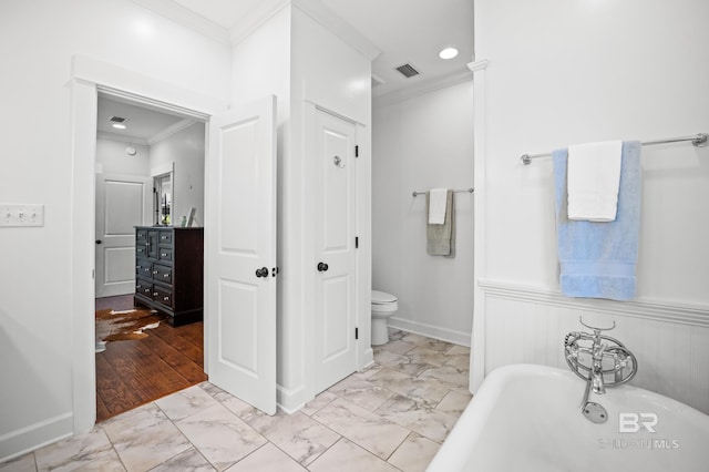 full bathroom with ornamental molding, toilet, visible vents, a freestanding bath, and marble finish floor