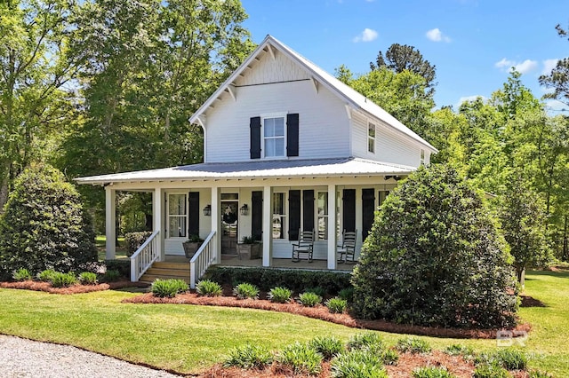 view of front of house with a front lawn, metal roof, and a porch