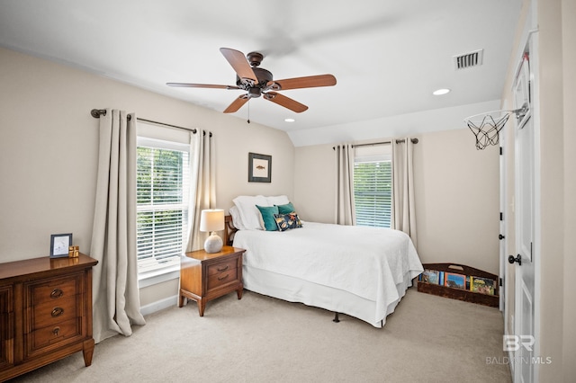 bedroom with visible vents, multiple windows, and light colored carpet