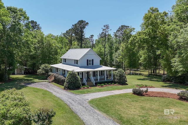 farmhouse with covered porch, a front yard, metal roof, and curved driveway