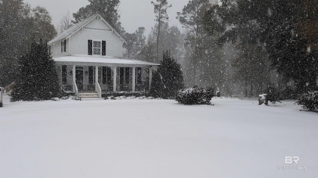 yard layered in snow featuring a porch