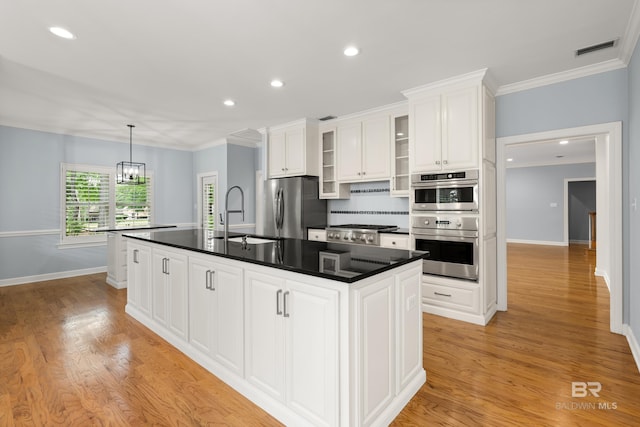 kitchen with a sink, stainless steel appliances, white cabinetry, and visible vents