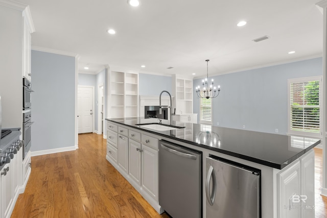 kitchen with stainless steel dishwasher, visible vents, dark countertops, white cabinetry, and a sink