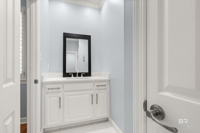 bathroom featuring crown molding, baseboards, and vanity