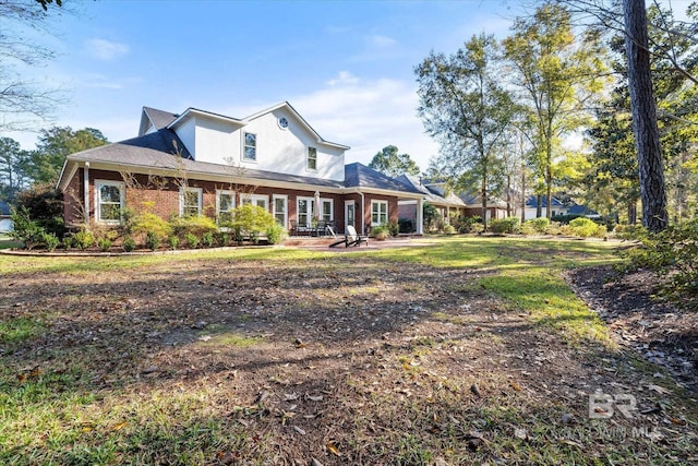 exterior space featuring brick siding, a patio, and stucco siding