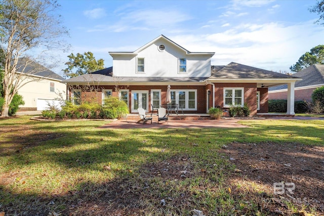 rear view of property featuring a lawn, stucco siding, and brick siding