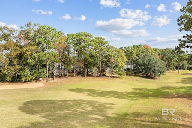view of property's community featuring golf course view and a yard