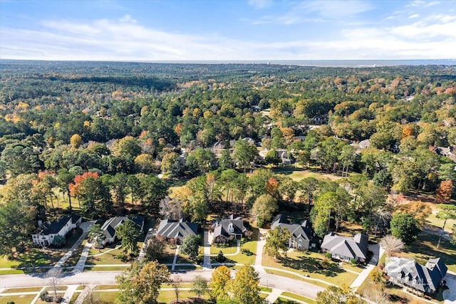 drone / aerial view featuring a residential view and a view of trees