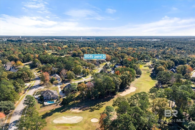 drone / aerial view featuring view of golf course and a forest view