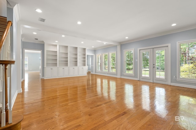 unfurnished living room featuring crown molding, baseboards, and visible vents
