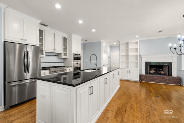 kitchen featuring dark countertops, recessed lighting, white cabinetry, a sink, and appliances with stainless steel finishes