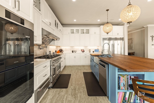 2282 W W Beach Blvd, Gulf Shores, AL 36542 - kitchen featuring wood counters, high quality appliances, under cabinet range hood, ornamental molding, and white cabinetry