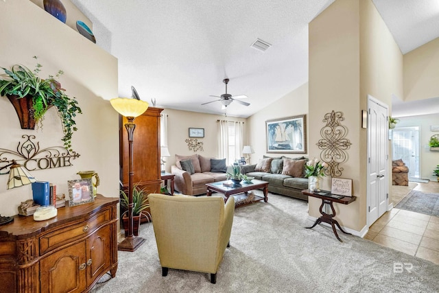 living room with ceiling fan, light tile patterned flooring, lofted ceiling, and a textured ceiling