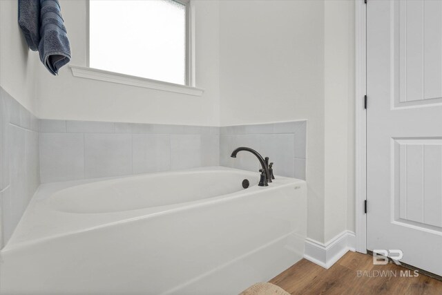 14437 Chenin Blanc Dr, Silverhill, AL 36576 - bathroom with a bath, wood finished floors, and baseboards