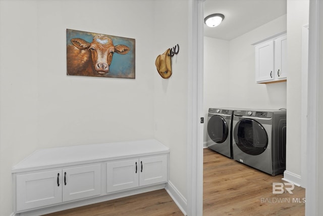14437 Chenin Blanc Dr, Silverhill, AL 36576 - laundry area with separate washer and dryer, light wood-style floors, cabinet space, and baseboards