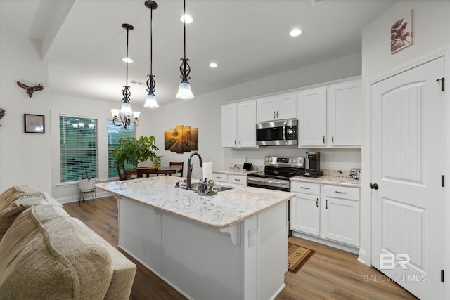 14437 Chenin Blanc Dr, Silverhill, AL 36576 - kitchen featuring stainless steel appliances, a sink, white cabinetry, light stone counters, and recessed lighting