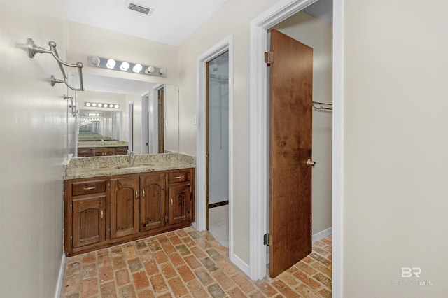9215 Shiloh Dr, Mobile, AL 36695 - bathroom with brick flooring, vanity, and a walk in closet