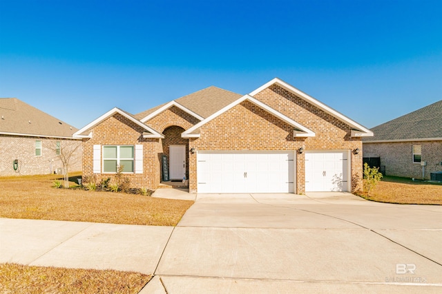 ranch-style home with brick siding, a garage, a front lawn, and concrete driveway