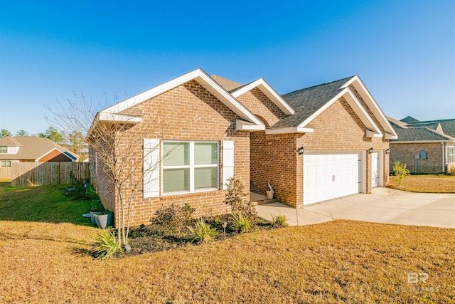 ranch-style house featuring fence, a front yard, brick siding, an attached garage, and driveway