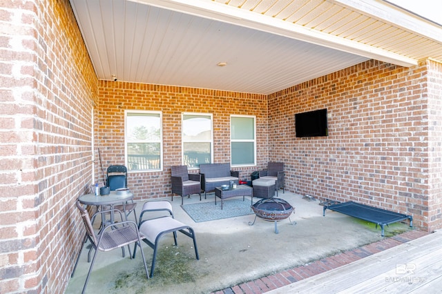 view of patio with an outdoor living space with a fire pit