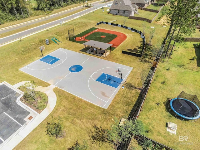 view of basketball court with fence, community basketball court, and a yard