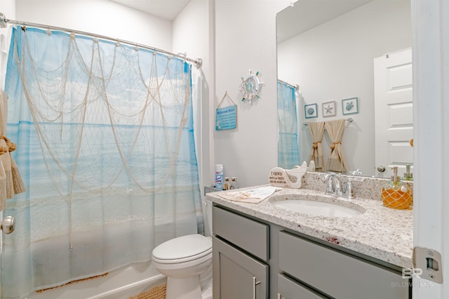 bathroom with vanity, shower / bath combo, and toilet