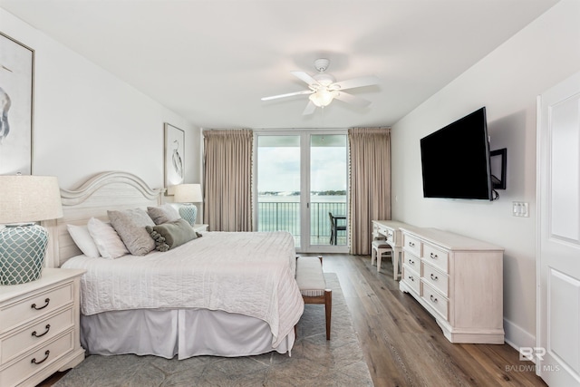 bedroom featuring ceiling fan, access to outside, a wall of windows, and dark wood-type flooring