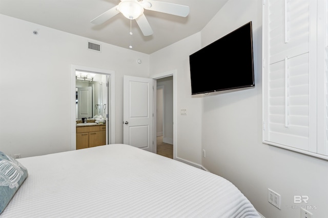 bedroom with ensuite bathroom, ceiling fan, a sink, visible vents, and baseboards