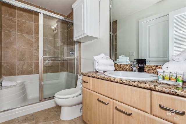 bathroom with toilet, tile patterned flooring, a shower stall, and vanity