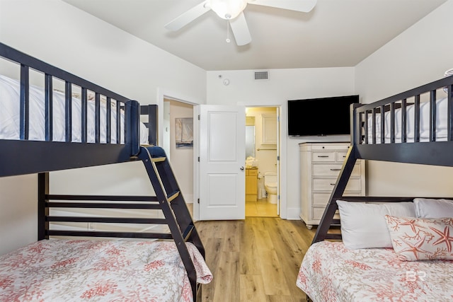 bedroom with ensuite bath, visible vents, ceiling fan, and wood finished floors