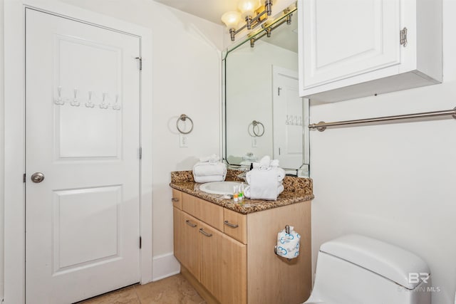 bathroom with toilet, tile patterned flooring, and vanity