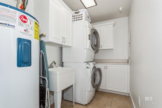 washroom featuring cabinet space, stacked washing maching and dryer, light tile patterned floors, and a sink