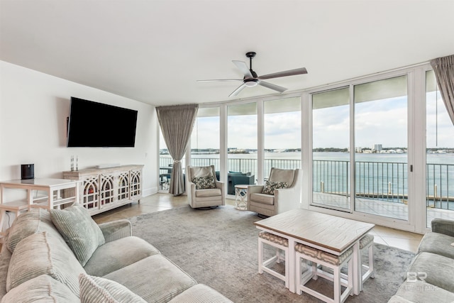 tiled living area with ceiling fan and a wall of windows