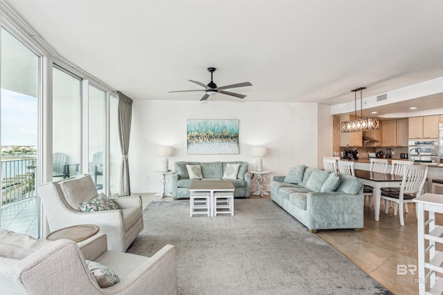 living room with light tile patterned floors, recessed lighting, visible vents, expansive windows, and ceiling fan