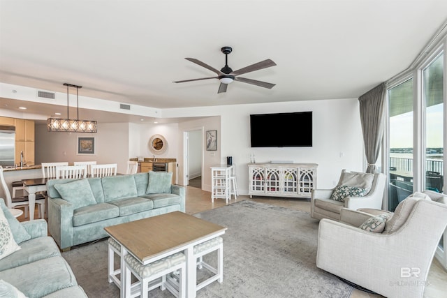 living room with a ceiling fan, recessed lighting, and visible vents