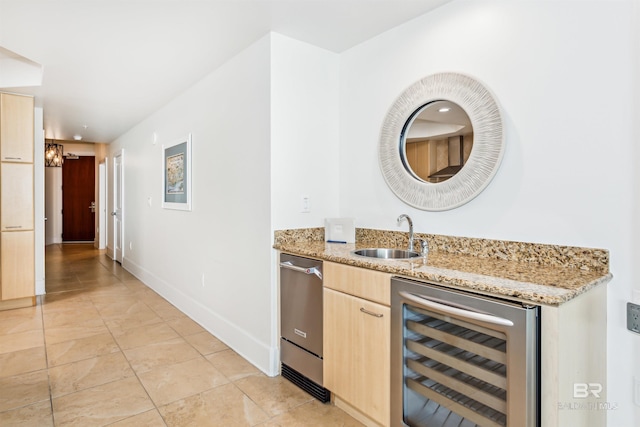 bar with beverage cooler, light tile patterned flooring, a sink, and baseboards