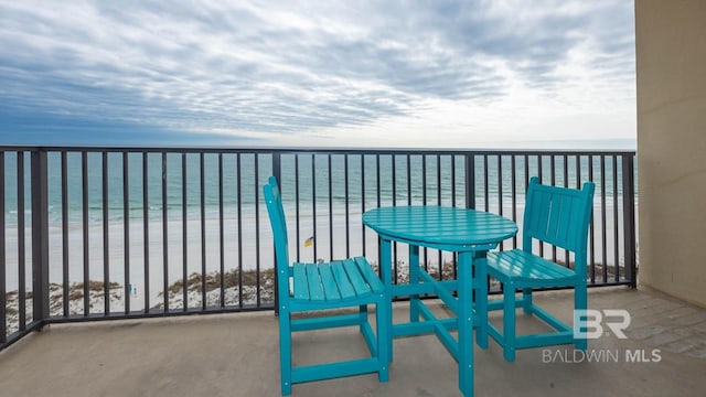 balcony with a water view and a beach view