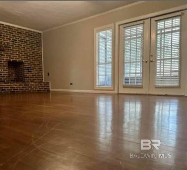 unfurnished living room featuring crown molding and french doors