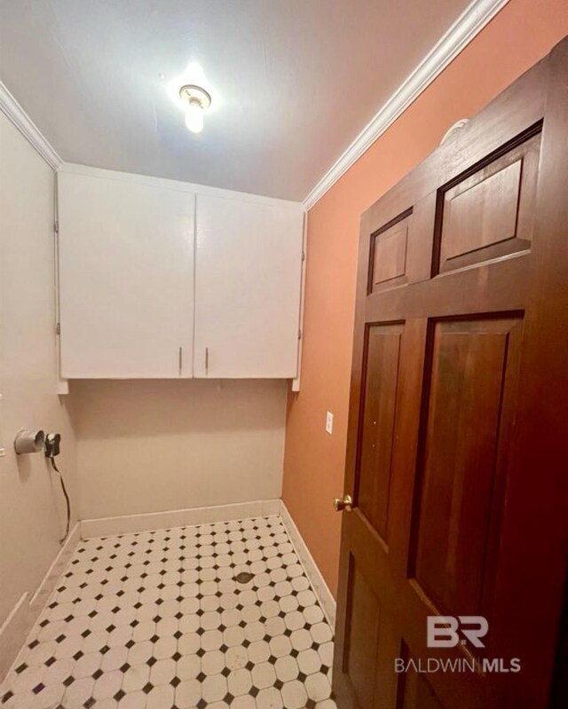 clothes washing area featuring cabinets and ornamental molding