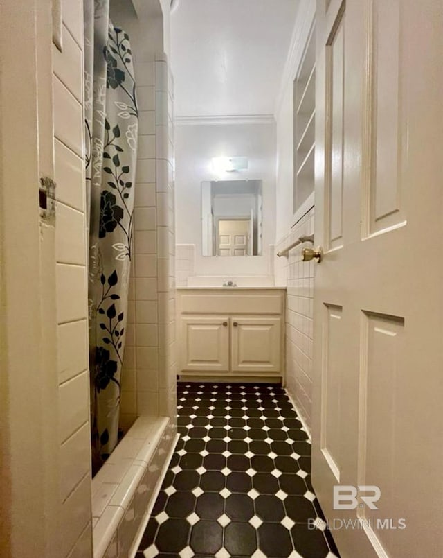 bathroom with vanity, curtained shower, and ornamental molding