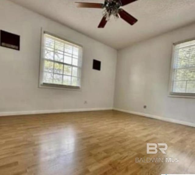 empty room with wood-type flooring and ceiling fan