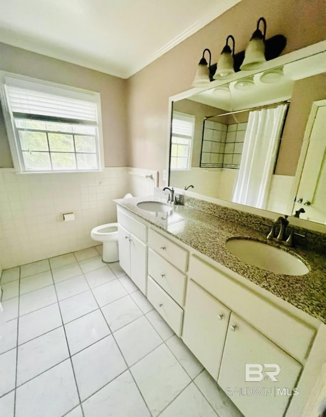 bathroom featuring tile patterned flooring, tile walls, vanity, ornamental molding, and toilet