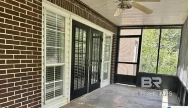 unfurnished sunroom featuring ceiling fan