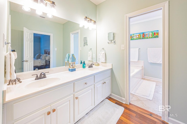 bathroom with vanity, hardwood / wood-style floors, and a bathing tub