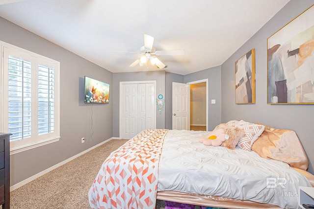 carpeted bedroom with ceiling fan and a closet