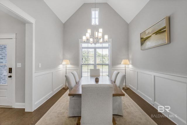 dining space with dark hardwood / wood-style flooring, a notable chandelier, and vaulted ceiling