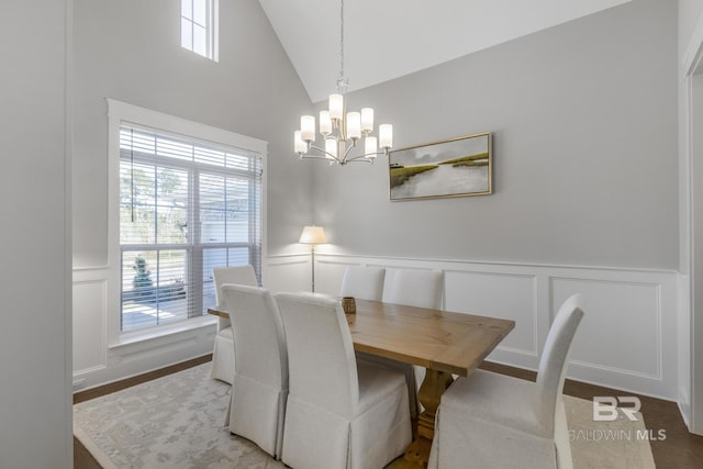 dining room with a notable chandelier, vaulted ceiling, and a wealth of natural light