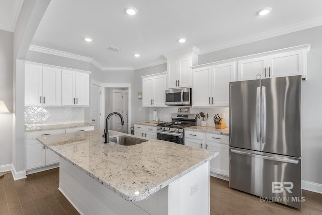 kitchen featuring white cabinetry, stainless steel appliances, a kitchen island with sink, and sink