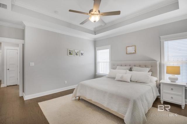 bedroom featuring crown molding, dark hardwood / wood-style flooring, and a raised ceiling