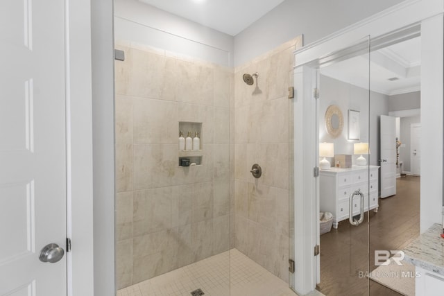 bathroom featuring ornamental molding, a tile shower, and vanity